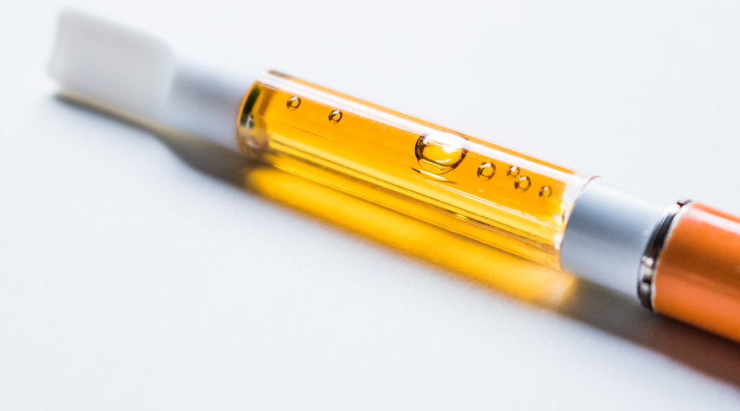 A vape cartridge filled with amber cannabis oil